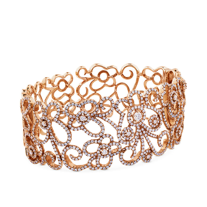 Pulsera ancha rígida de oro rosa y diamantes talla brillante.