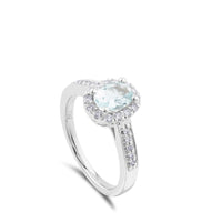 Sortija de oro blanco y diamantes con aguamarina y orla de pavé de diamantes