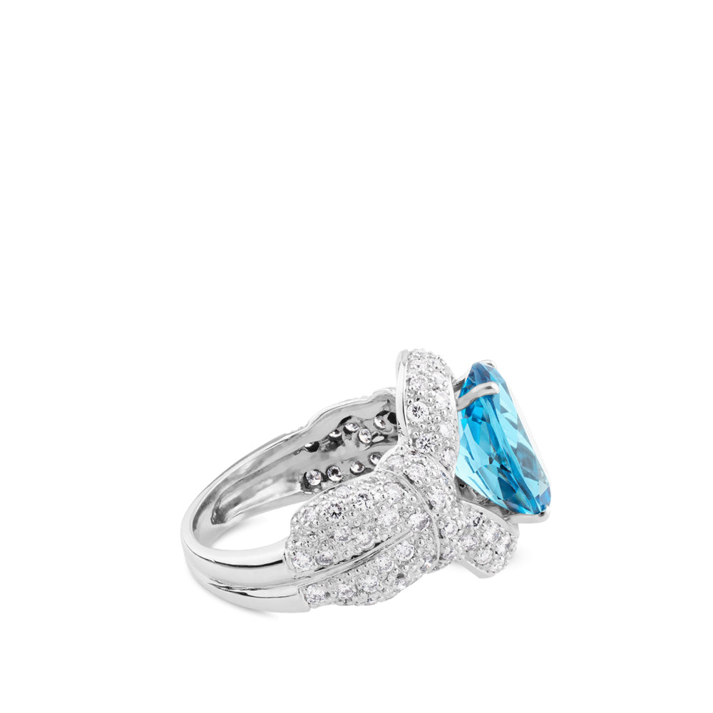 Sortija de oro blanco con topacio azul oval y pavé de diamantes