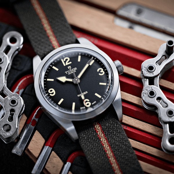Tudor_Ranger_esfera_negra_36mm_correa_de_tejido_vista_encima_mesa_con_herramientas