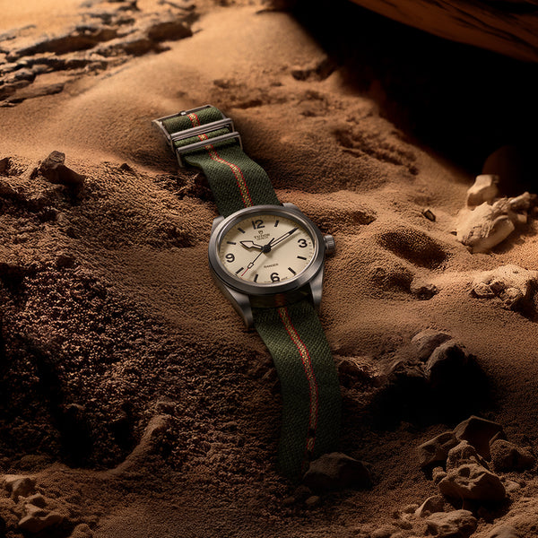 Tudor_Ranger_esfera_beige_39mm_correa_tejido_m79950-0011_vista_sobre_arena_del_desierto