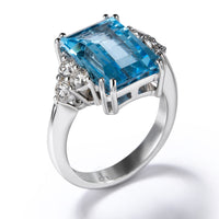 Sortija "Caramelo" de oro blanco con diamantes y topacio azul talla esmeralda