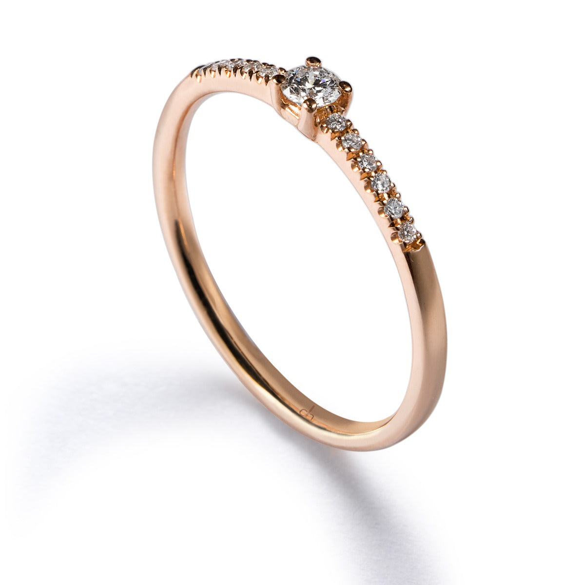 Solitario "Isabella" de oro rosa con diamante talla brillante y diamantes en garra