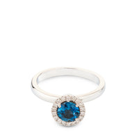 Sortija de oro blanco con diamantes y topacio azul en altura