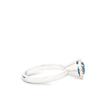 Sortija de oro blanco con diamantes y topacio azul en altura