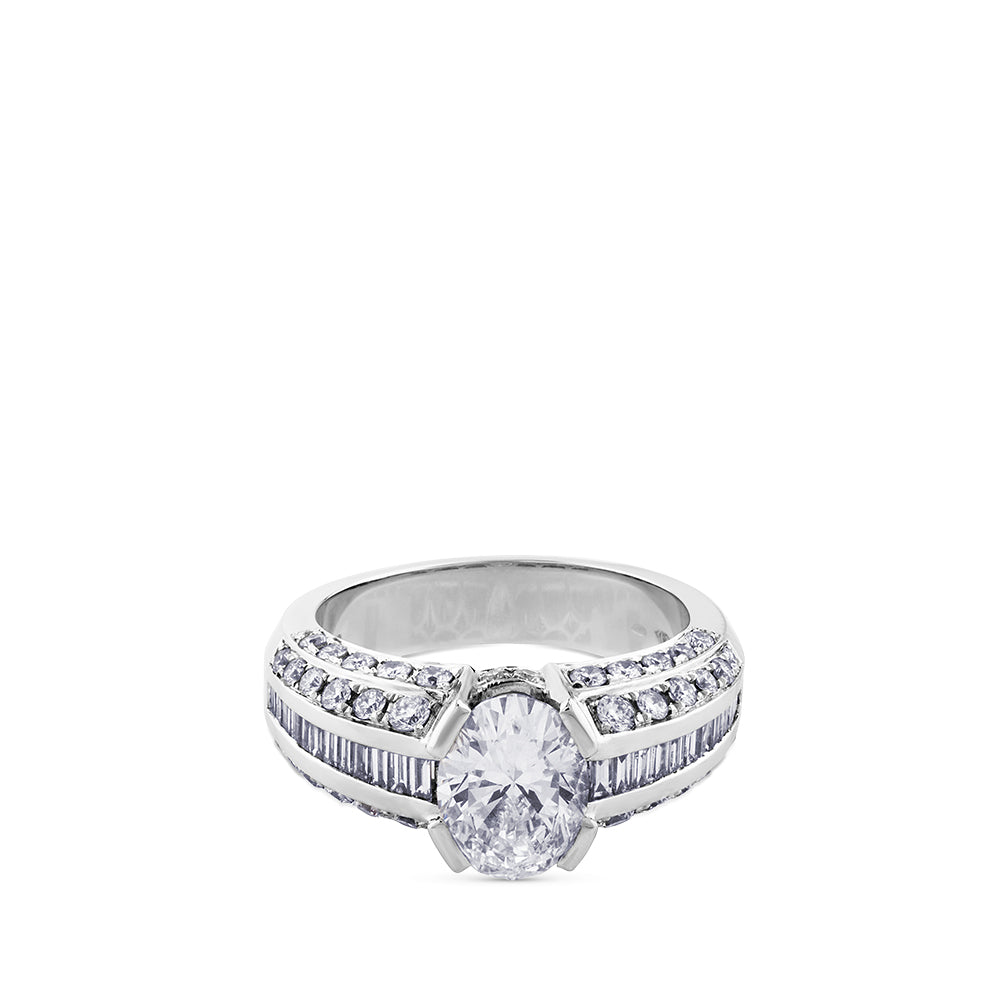 Solitario de oro blanco con diamante oval y diamantes talla baguette y brillante en montura
